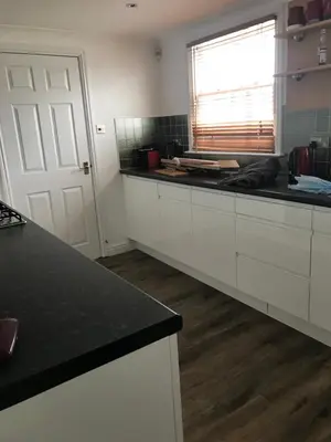a kitchen with white cabinets and a black counter top at 5 Hatfield Cresent in Newquay