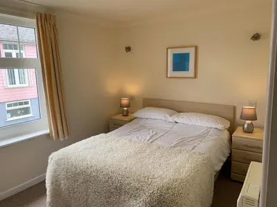 a bedroom with a bed and two night stands with two lamps at Manor Lodge in Newquay
