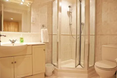 a bathroom with a shower and a toilet and a sink at Manor Lodge in Newquay