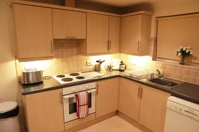 a kitchen with wooden cabinets and a stove top oven at Manor Lodge in Newquay