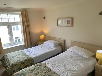 a bedroom with two beds and a window at Manor Lodge in Newquay