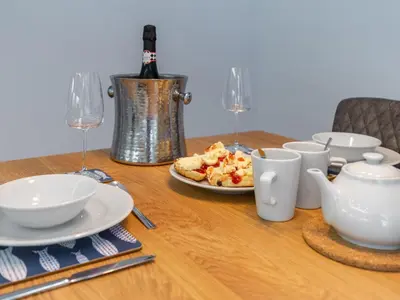 a table with a plate of food and a bottle of wine at Holiday Home Sea Compass by Interhome in Charlestown