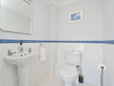 a white bathroom with a toilet and a sink at Holiday Home Sea Compass by Interhome in Charlestown