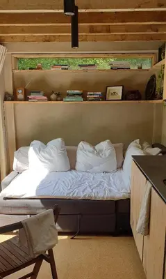 a bed in a room with books on a shelf at Studio Portland in Falmouth