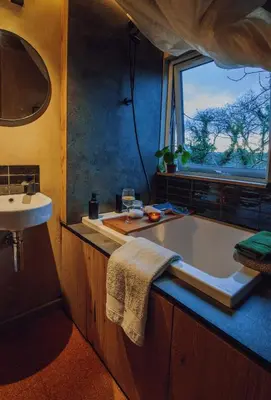 a bathroom with a tub and a sink and a window at Studio Portland in Falmouth