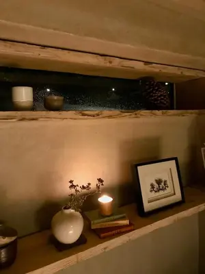 a shelf with a vase and a candle and books at Studio Portland in Falmouth