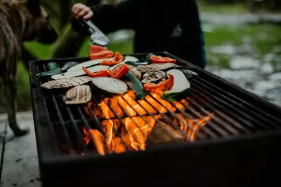 a person is cooking food on a grill at Kudhva 4 in Treknow