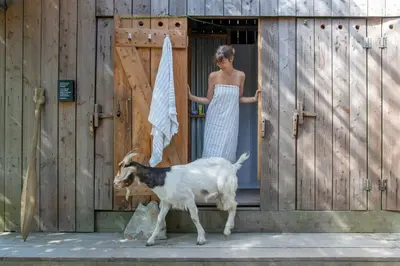 a woman standing in a doorway with a goat at Kudhva 3 in Treknow