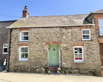 an old stone house with a green door at Rock Cottage in St. Issey