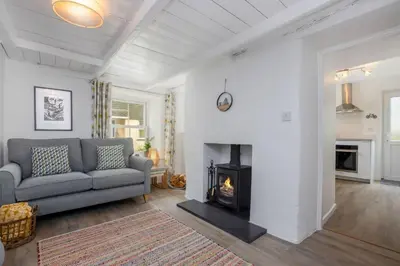 a living room with a couch and a fireplace at Rock Cottage in St. Issey