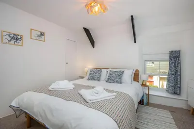 a bedroom with a bed with two towels on it at Rock Cottage in St. Issey