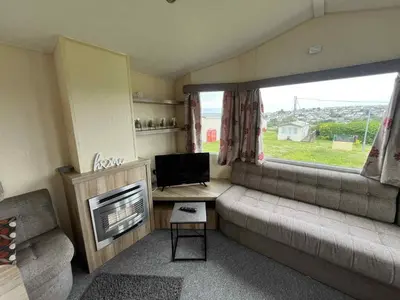 a small living room with a couch and a television at Sea Shanty in Newquay
