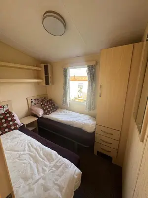 a small bedroom with two beds and a window at Sea Shanty in Newquay