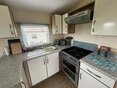 a small kitchen with a stove and a sink at Sea Shanty in Newquay