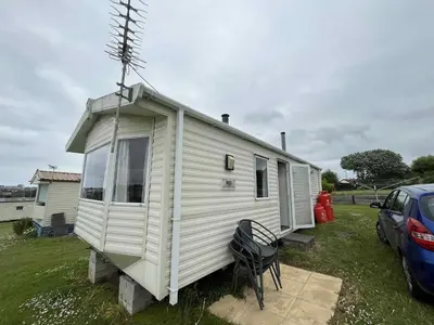 a white tiny house sitting in a yard at Sea Shanty in Newquay