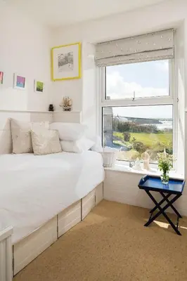 a bedroom with a large bed and a window at Beautiful family house with amazing sea views in Padstow
