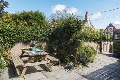 a wooden picnic table sitting in a garden at Beautiful family house with amazing sea views in Padstow