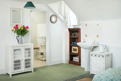 a bathroom with a sink and a vase of flowers at Beautiful family house with amazing sea views in Padstow