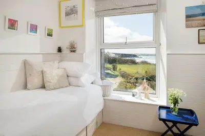 a bedroom with a white bed and a window at Beautiful family house with amazing sea views in Padstow
