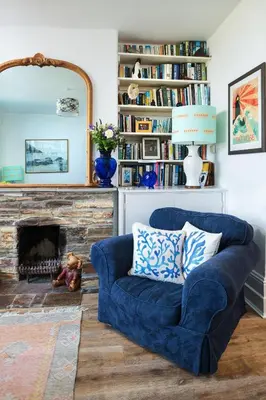 a blue couch in a living room with a fireplace at Beautiful family house with amazing sea views in Padstow