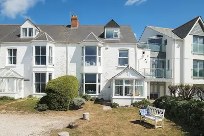 a large white house with a bench in the yard at Beautiful family house with amazing sea views in Padstow