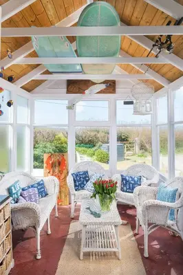 a room with white wicker chairs and a table at Beautiful family house with amazing sea views in Padstow