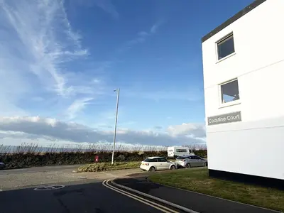 a car parked in a parking lot next to a building at 8 Coastline Apartment in Newquay