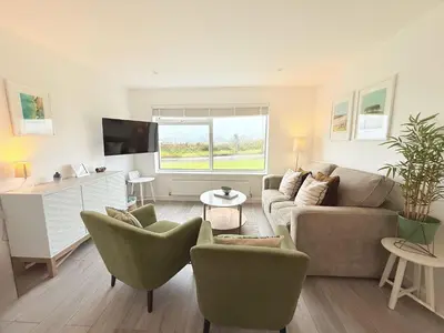 a living room with a couch and chairs at 8 Coastline Apartment in Newquay