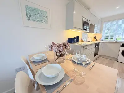 a kitchen with a table with plates and bowls on it at 8 Coastline Apartment in Newquay