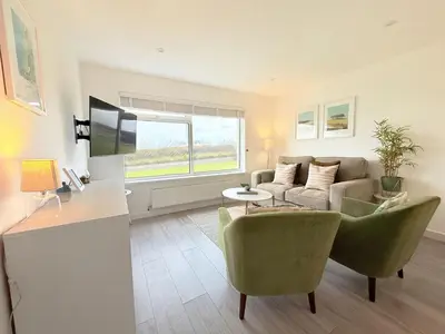 a living room with a couch and a table at 8 Coastline Apartment in Newquay
