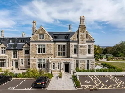 a large house with a parking lot in front of it at Treloyhan Manor St Ives in St Ives