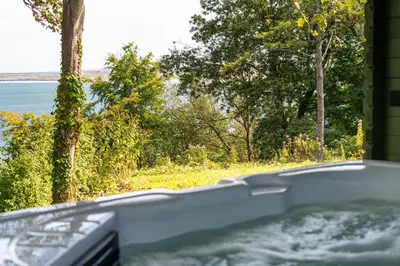 a bath tub with a view of the water at Treloyhan Manor St Ives in St Ives