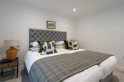 a bedroom with a large bed with green and white pillows at Treloyhan Manor St Ives in St Ives