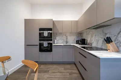 a kitchen with white cabinets and a stove top oven at Treloyhan Manor St Ives in St Ives