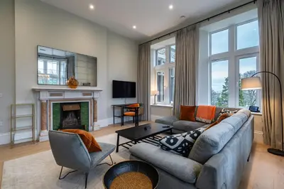 a living room with a couch and a fireplace at Treloyhan Manor St Ives in St Ives