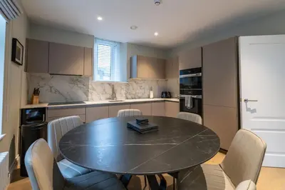 a kitchen with a dining room table and chairs at Treloyhan Manor St Ives in St Ives