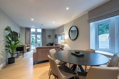 a living room with a table and chairs at Treloyhan Manor St Ives in St Ives