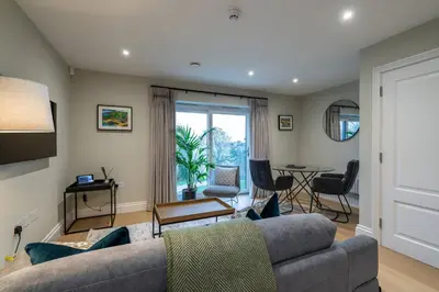 a living room with a couch and a table at Treloyhan Manor St Ives in St Ives