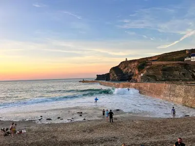 a group of people on a beach near the ocean at Mermaid Cove in Portreath