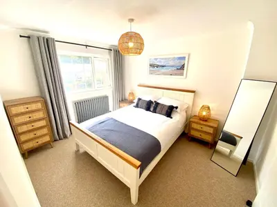 a bedroom with a bed and a large window at Mermaid Cove in Portreath