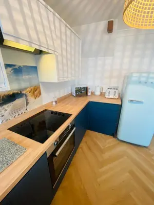 a kitchen with blue cabinets and a blue refrigerator at Mermaid Cove in Portreath