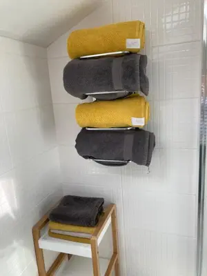 a bathroom with a pile of towels on a wall at Blaise Cottage Cornwall in St Austell