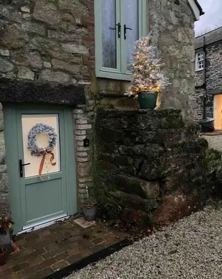 a door of a stone house with a wreath on it at Blaise Cottage Cornwall in St Austell