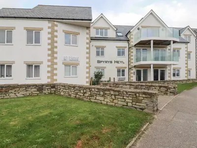 a large white house with a stone wall at Apartment 6 in Newquay