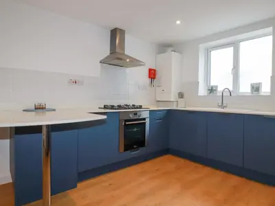 a kitchen with blue cabinets and a sink at Apartment 6 in Newquay