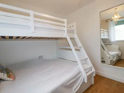 a bedroom with two bunk beds and a mirror at Apartment 6 in Newquay