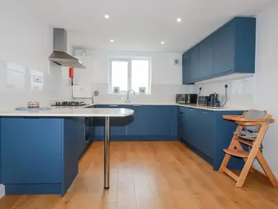 a kitchen with blue cabinets and a white counter top at Apartment 6 in Newquay