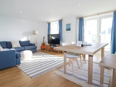 a living room with a table and a blue couch at Apartment 6 in Newquay