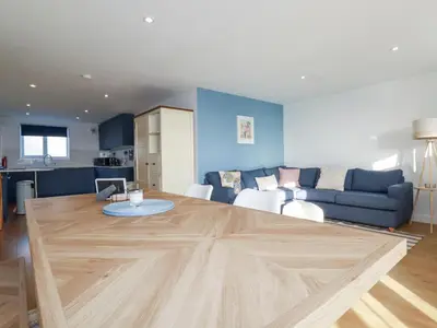 a living room with a large wooden table at Apartment 6 in Newquay