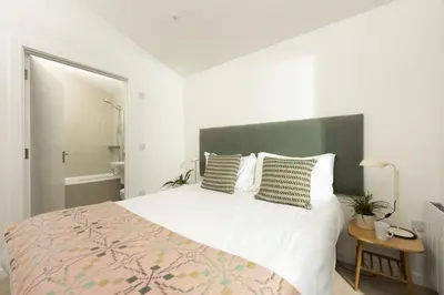 a bedroom with a large bed with a green headboard at 71 Una, Carbis Bay in Carbis Bay